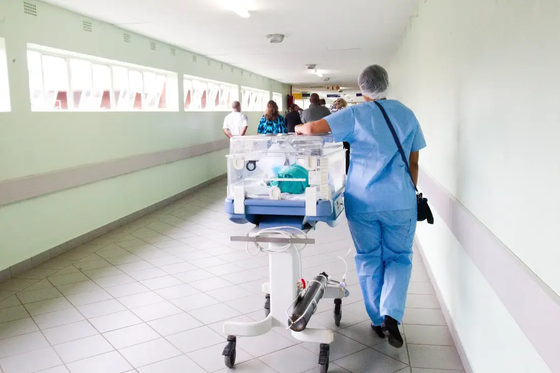 Personal de salud trasladando a un paciente por el pasillo del hospital